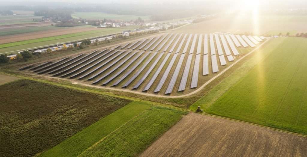 Solarpark in Ennsdorf mit zahlreichen Solarmodulen bei Sonnenaufgang.