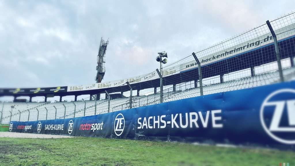 Absperrung bei einem Motorsport-Event mit Sponsorenwerbung.