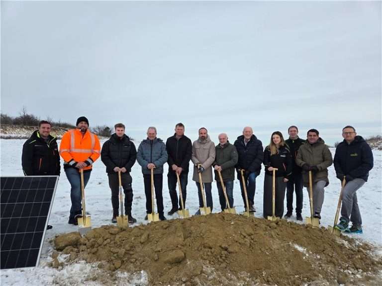 Gruppe von Menschen bei Baumpflanzung für nachhaltige Energie.